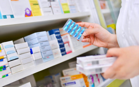 pharmacist-holding-medicine-box-capsule-pack-pharmacy-drugstore.jpg