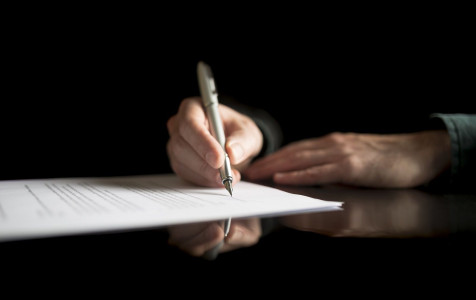 low-view-businessman-hand-signing-legal-insurance-document-business-contract-black-desk-with-reflection.jpg